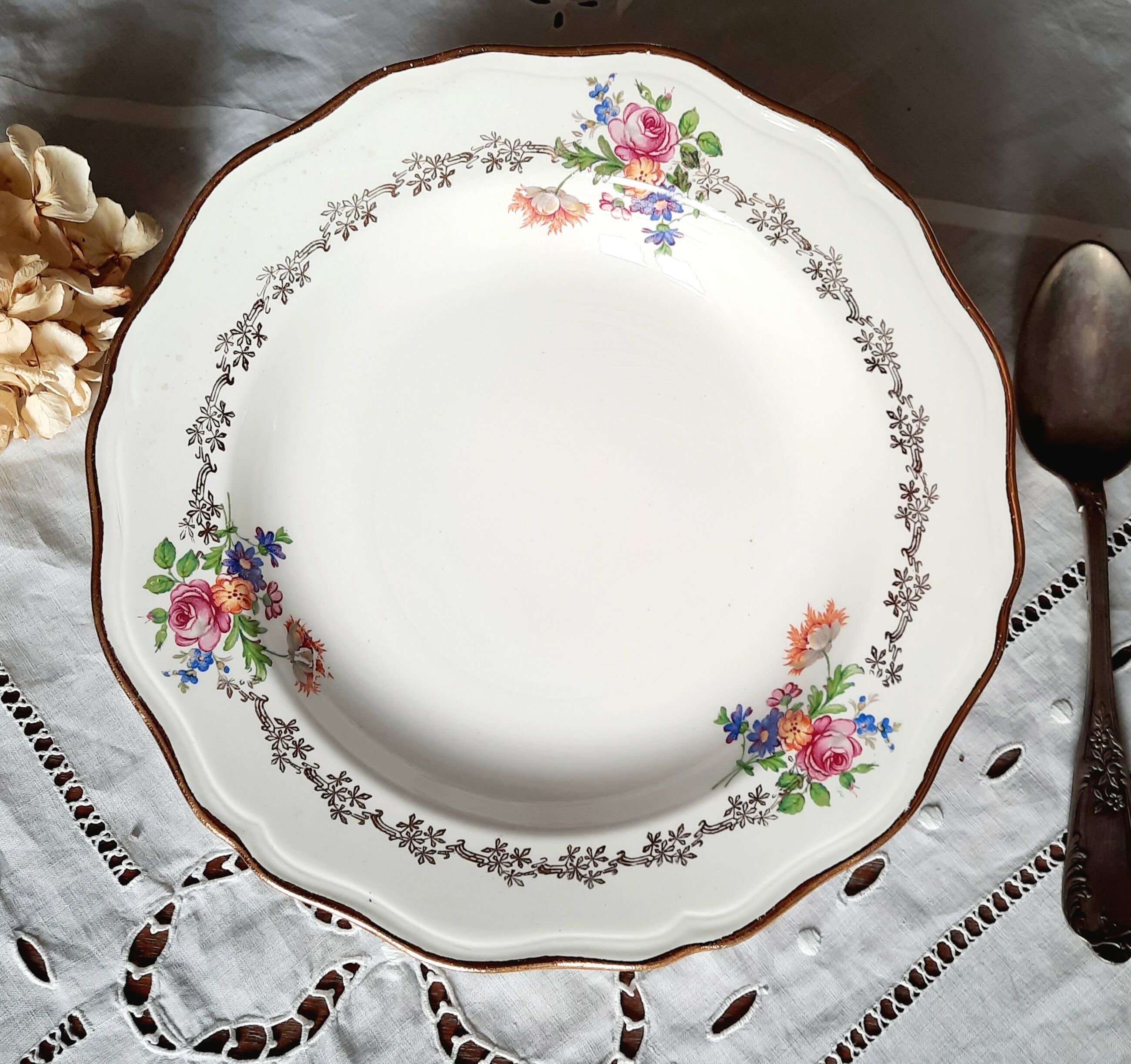 Old hollow plates mismatched in earthenware with gilded edges