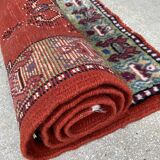 Vintage hand-knotted wool rug with polychrome decoration on a red, blue, green background 150 x 63 cm