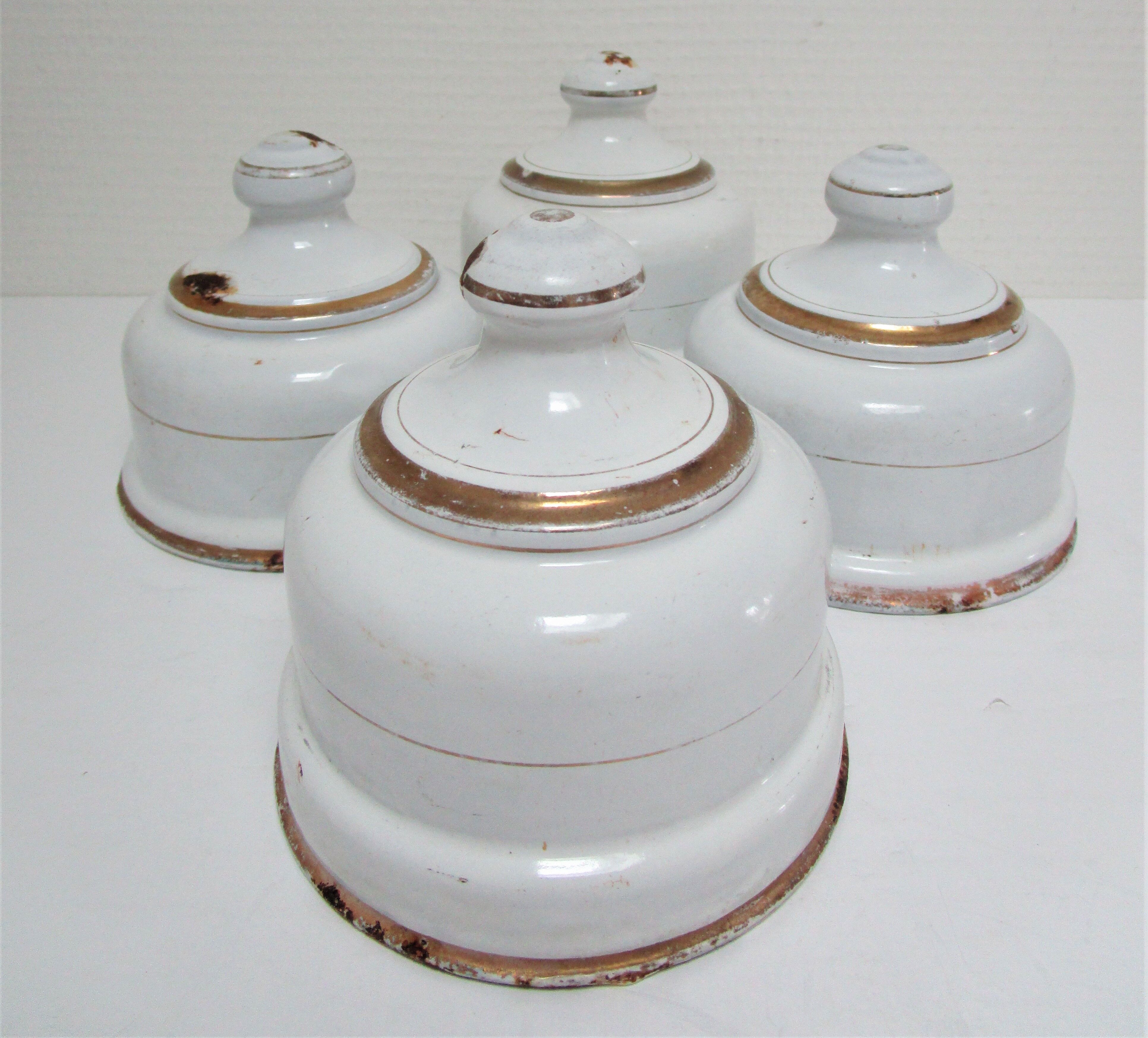 Four white enamelled metal cheese bells early twentieth century