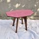 Small Scandinavian side table with wood and pink tiles, with tapered legs.