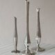 Set of three lightweight silver-coloured metal vases.
