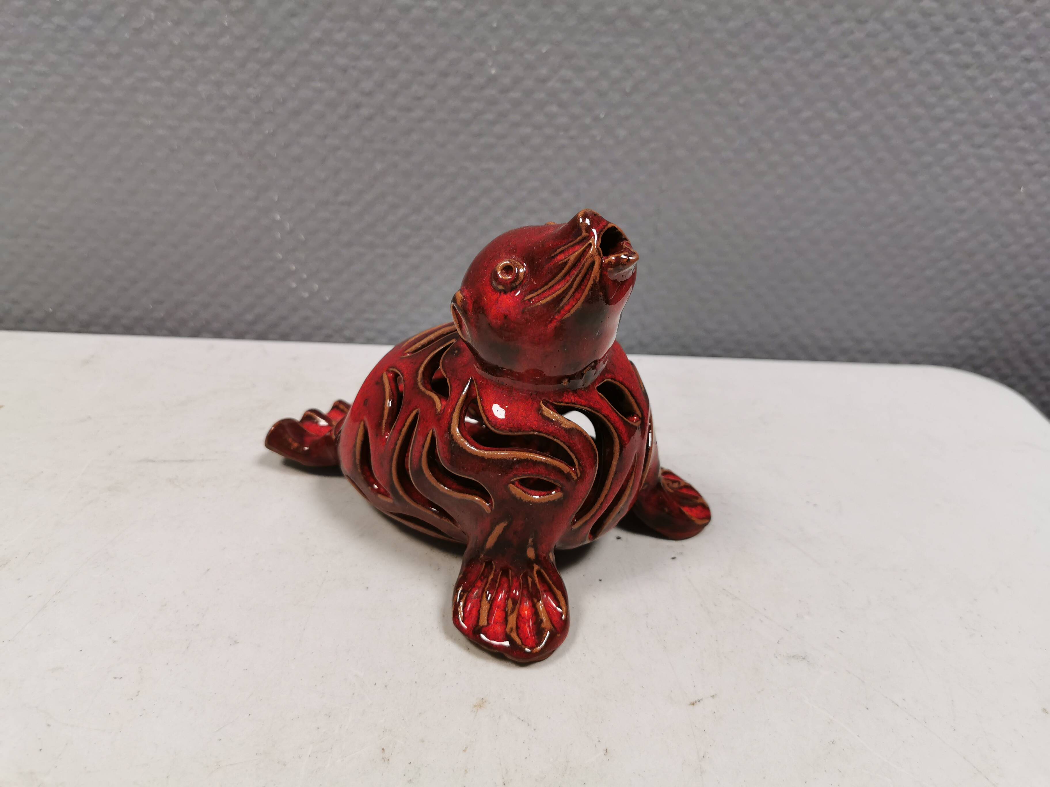 Beautiful seal in ceramic with metallic red glaze.