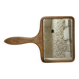Old beveled hand mirror and wooden frame