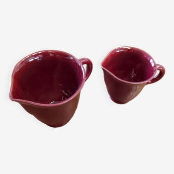 2 pitchers or milk jugs, vintage, red ceramic, numbered.