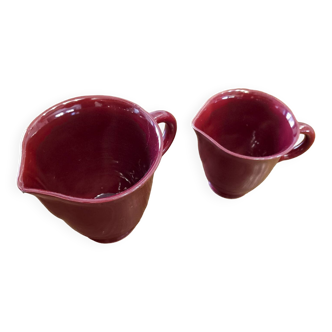 2 pitchers or milk jugs, vintage, red ceramic, numbered.