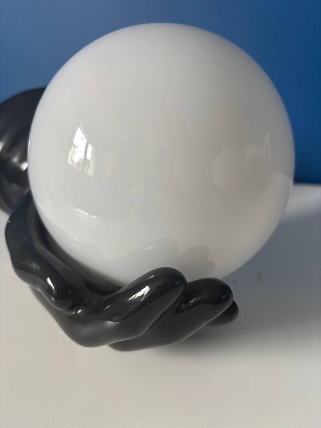 Vintage wall sconce with black hand and white opaline glass globe, 1970s L
