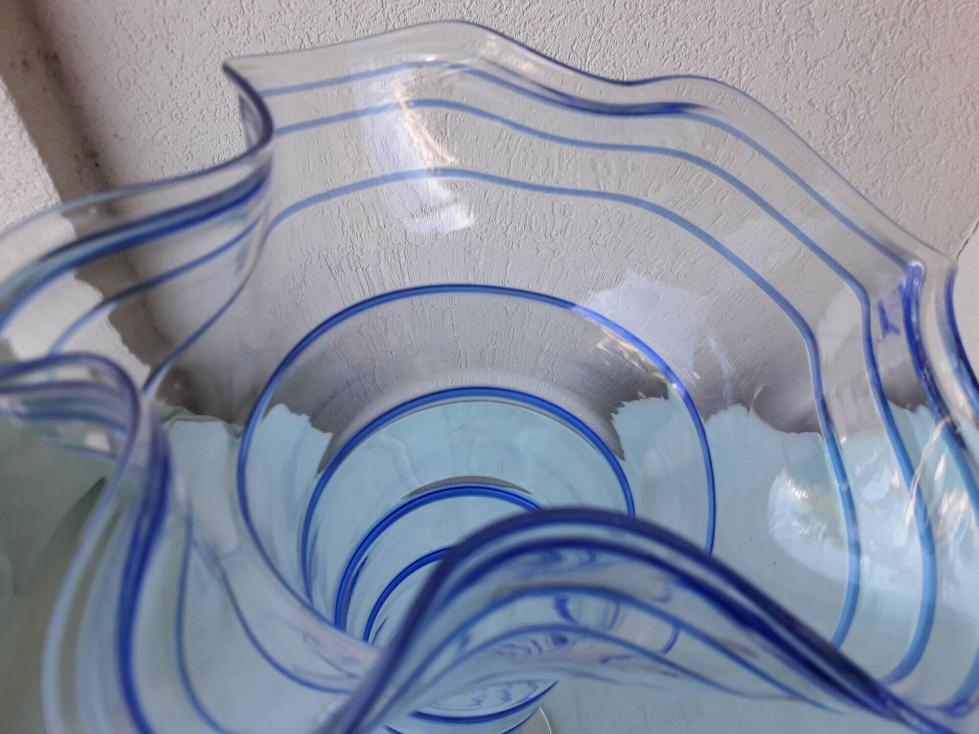 Glass vase on a pedestal with a blue trim.