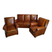 Living room with a sofa and wingback armchairs.