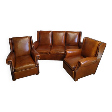 Living room with a sofa and wingback armchairs.