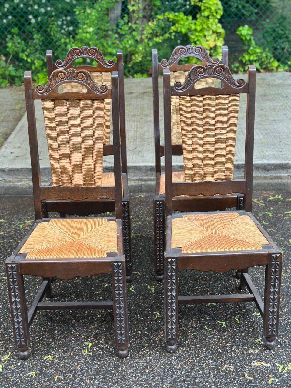 4 Basque solid wood dining chairs with carved straw seats.