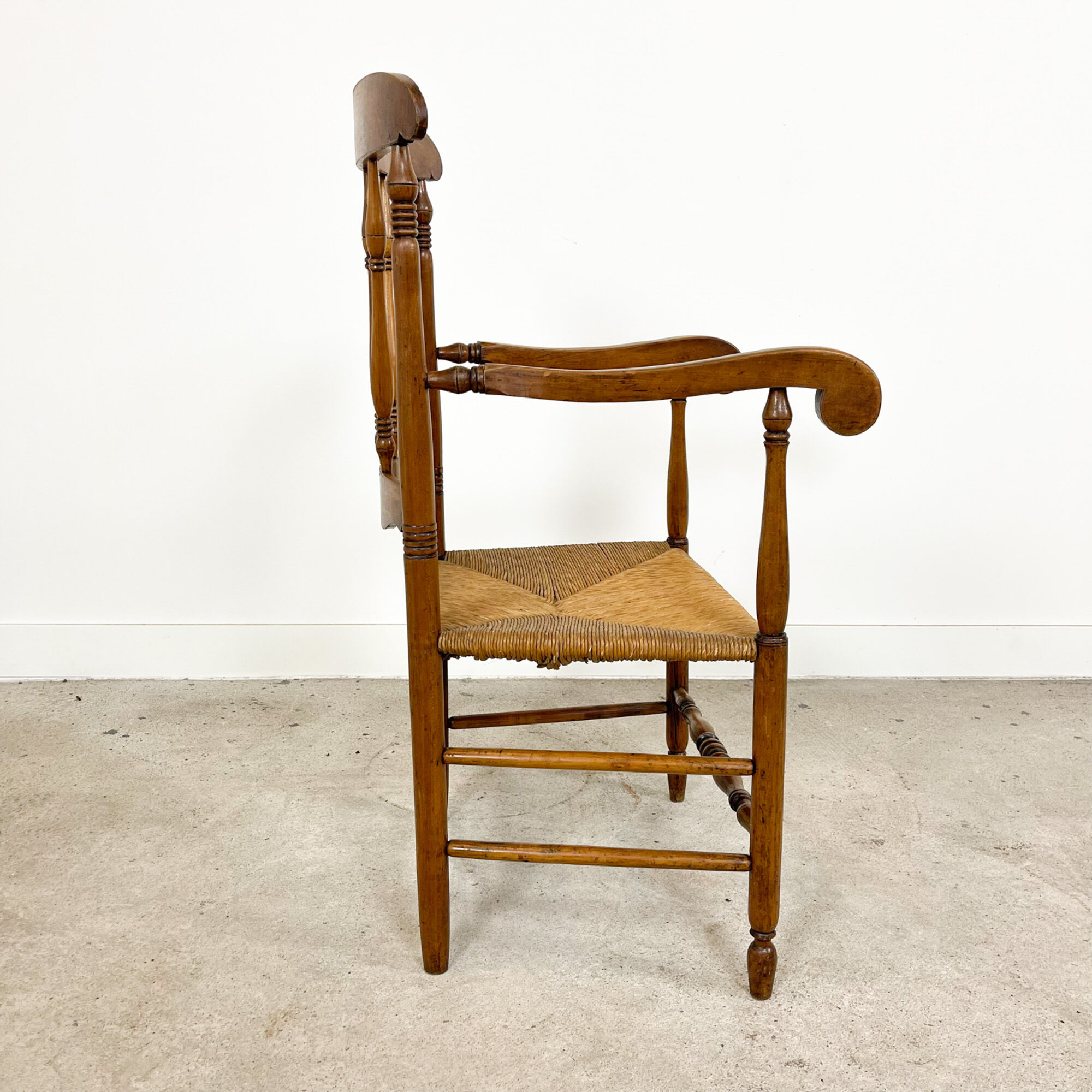 Antique oak and elm wooden armchair with cane seat