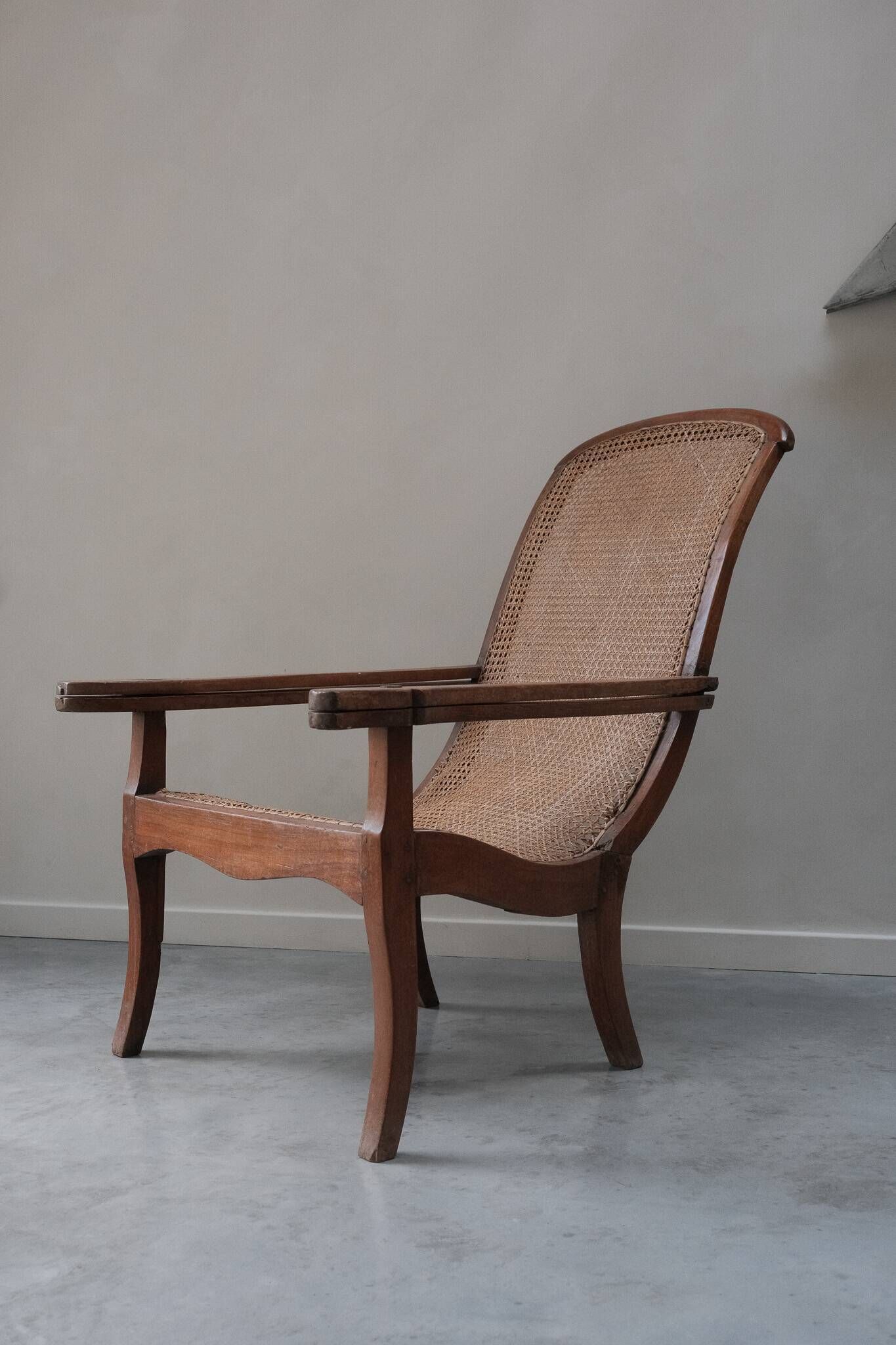 Fauteuil avec assise en cannage et accoudoirs pivotants