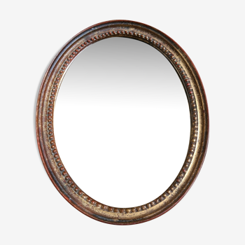 Old oval mirror in gilded wood