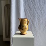 Large antique handmade ochre yellow jug with a pink flower pattern.