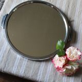 A large round mirror tray with metal handles