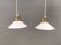 Two small hanging lamps in milky white glass with brass-coloured tops.
