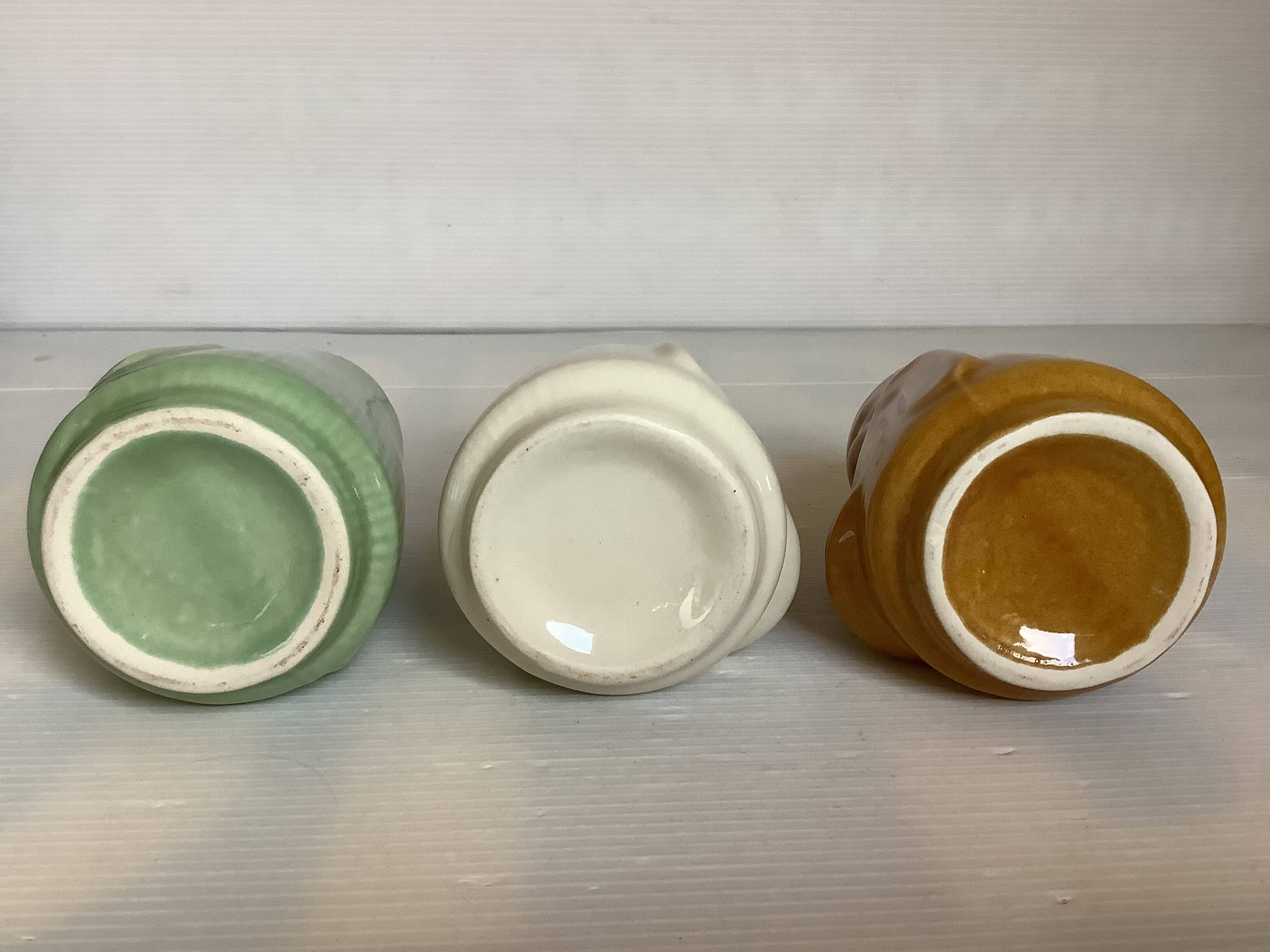 Set of three small Moai-style head vases.