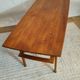 Scandinavian coffee table in teak with a lower shelf and brass bars.