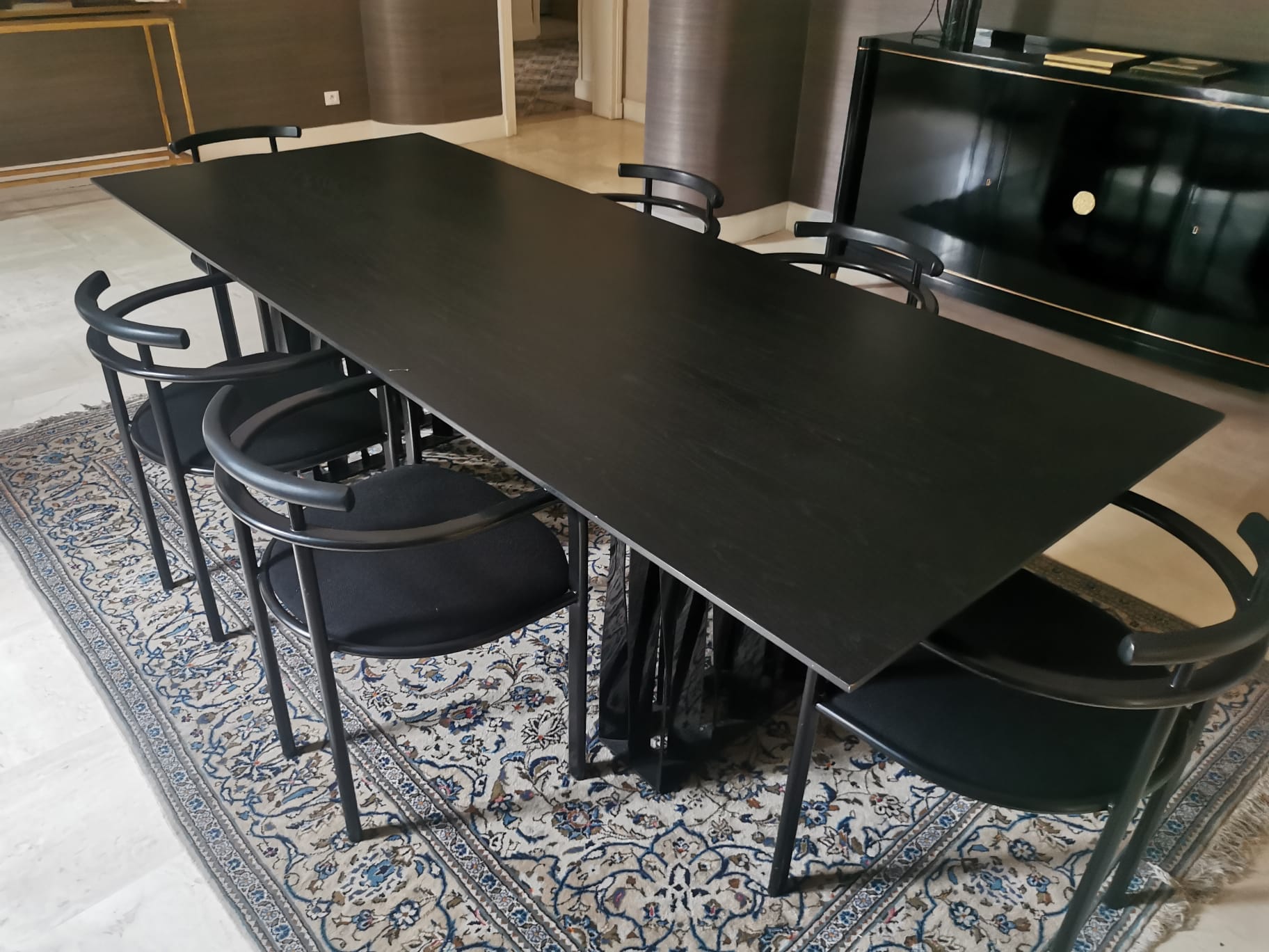 Black dining room table, wooden, rectangle with upholstered chairs.