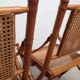 Pair of folding chairs in bamboo and caning, leather and brass
