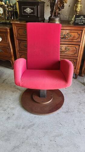 Old cinema chair with a red reclining seat.