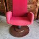 Old cinema chair with a red reclining seat.