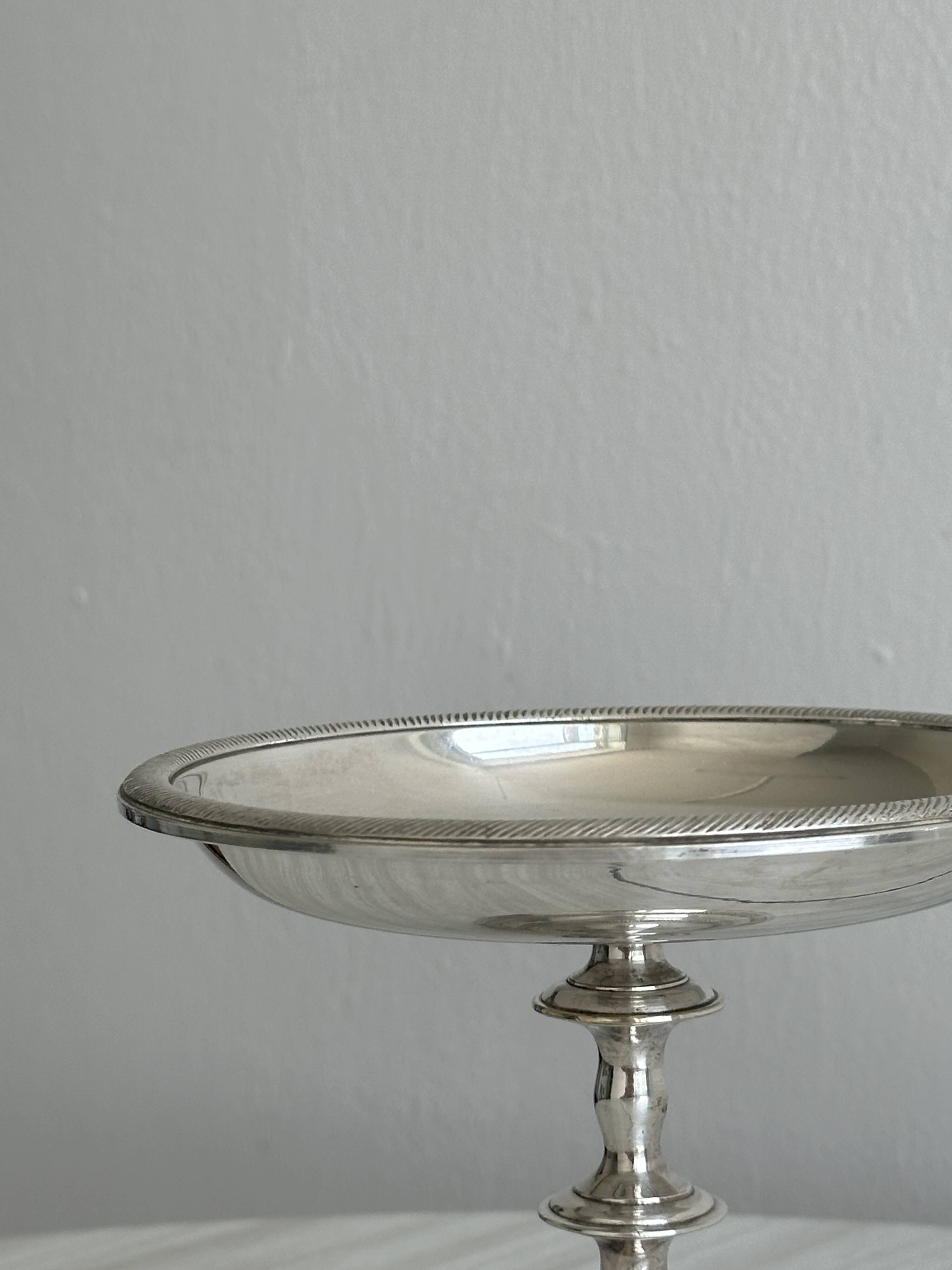 Silver-plated metal stand.