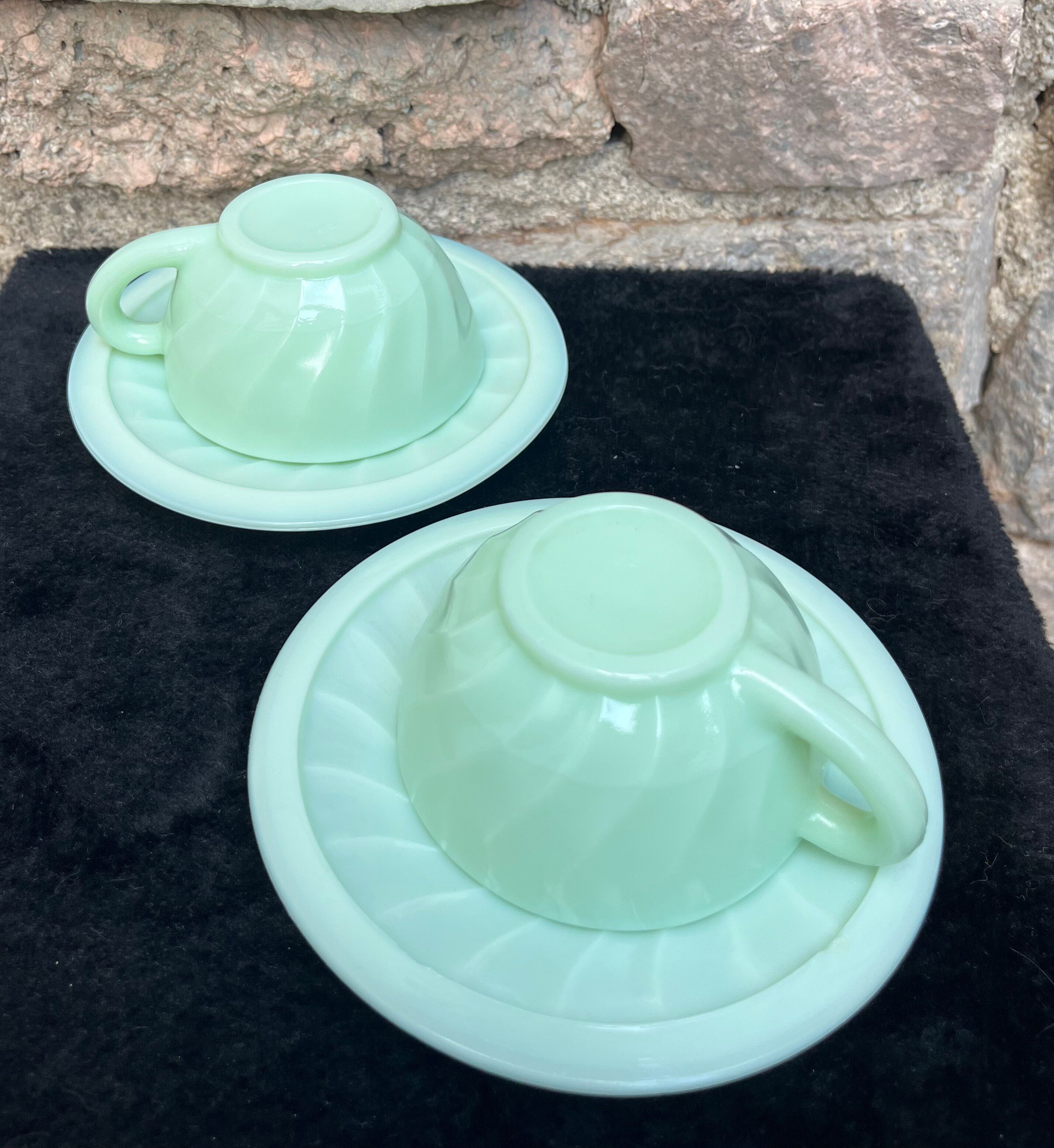 Two green opaline cup and saucer sets.