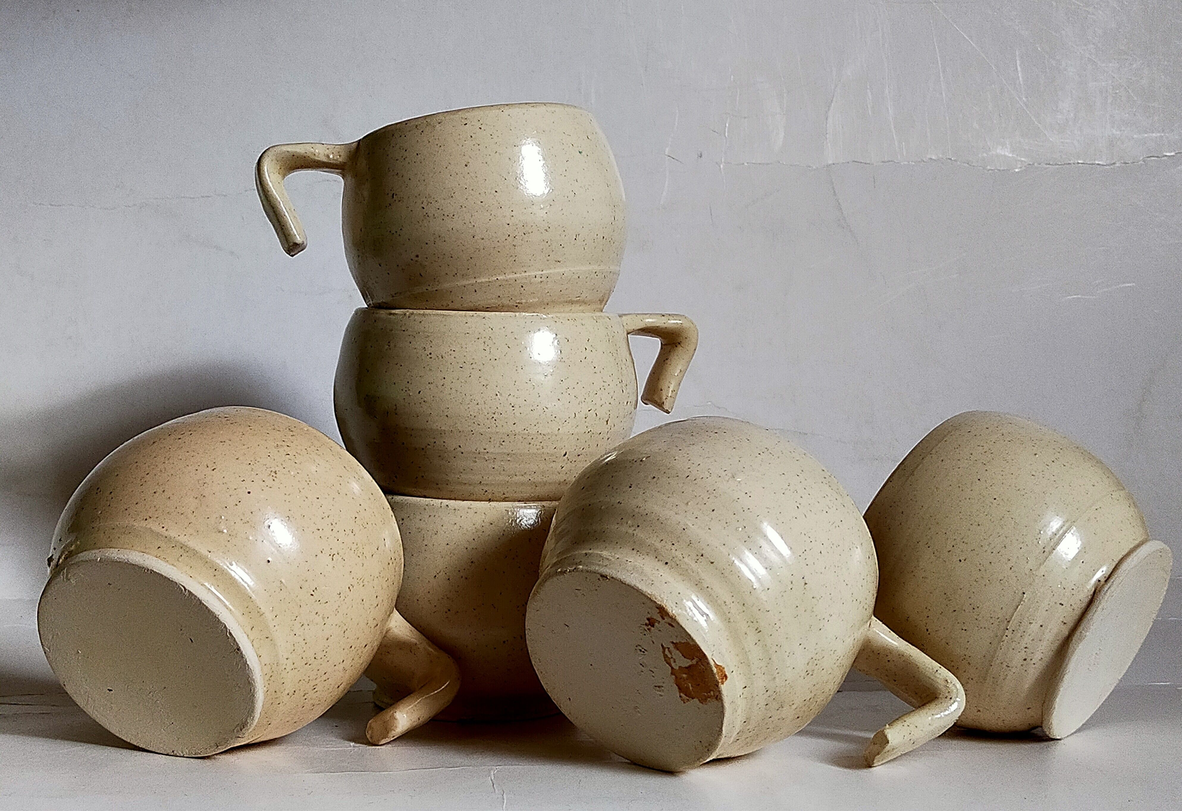 Six vintage potter's ceramic cups with vanilla enamel