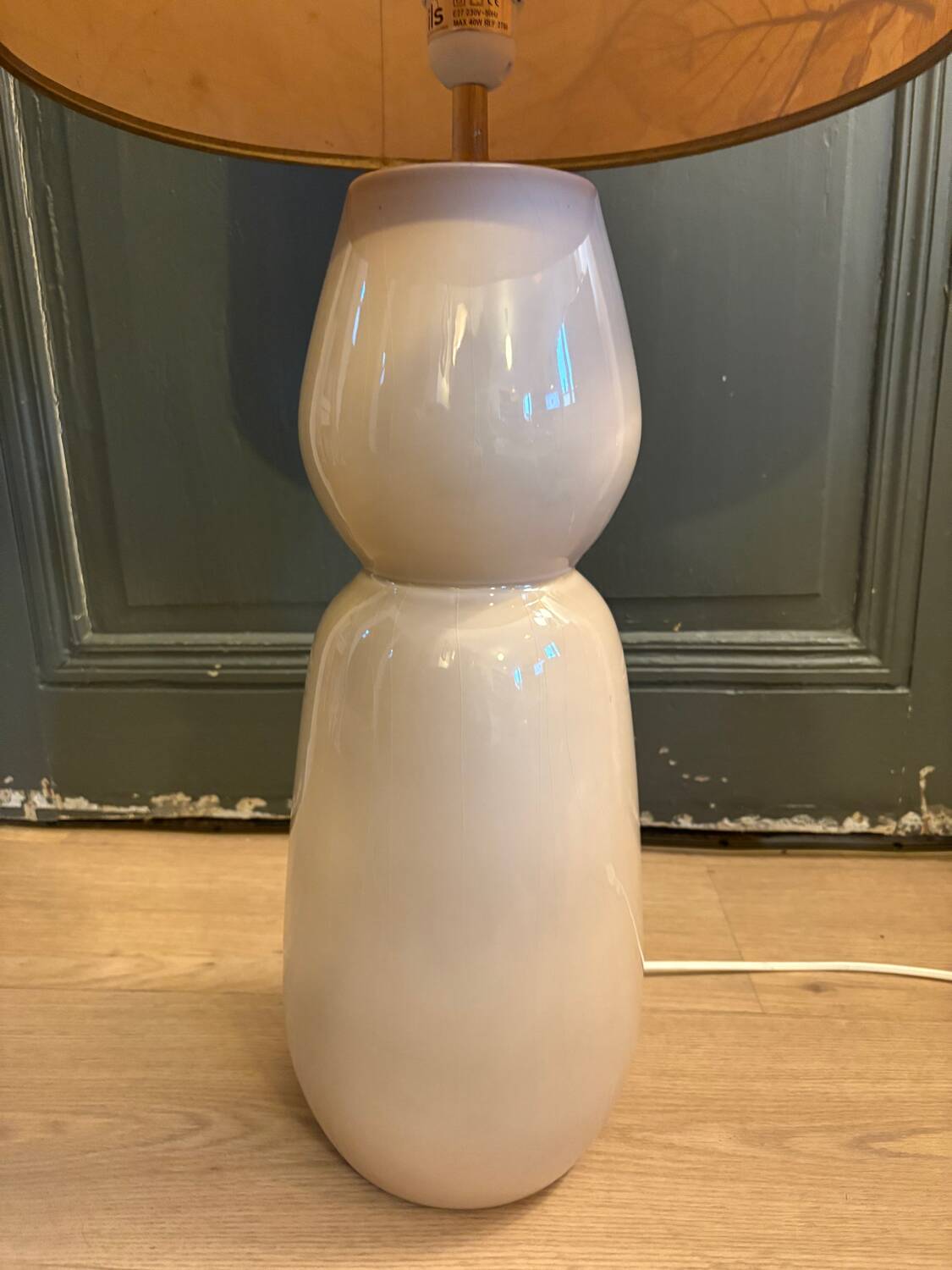 Large beige ceramic table lamp with a vintage shade.