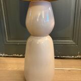 Large beige ceramic table lamp with a vintage shade.
