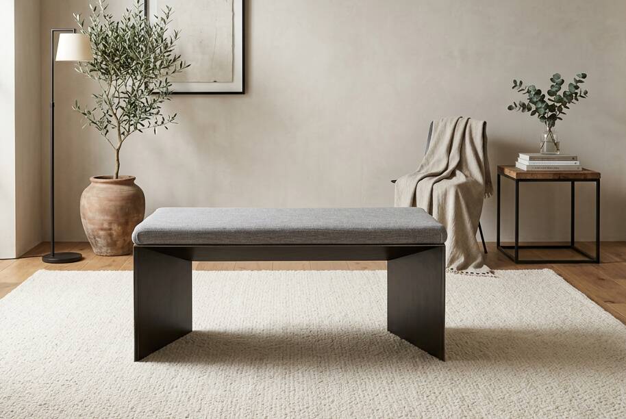 Minimalist/industrial coffee table with a black metal frame and a grey fabric top.