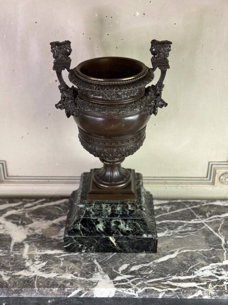 Patinated bronze vase with handles topped by bicéphalic busts, 19th century.