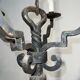 Two-tiered wrought iron chandelier with eight light arms in Gothic style.