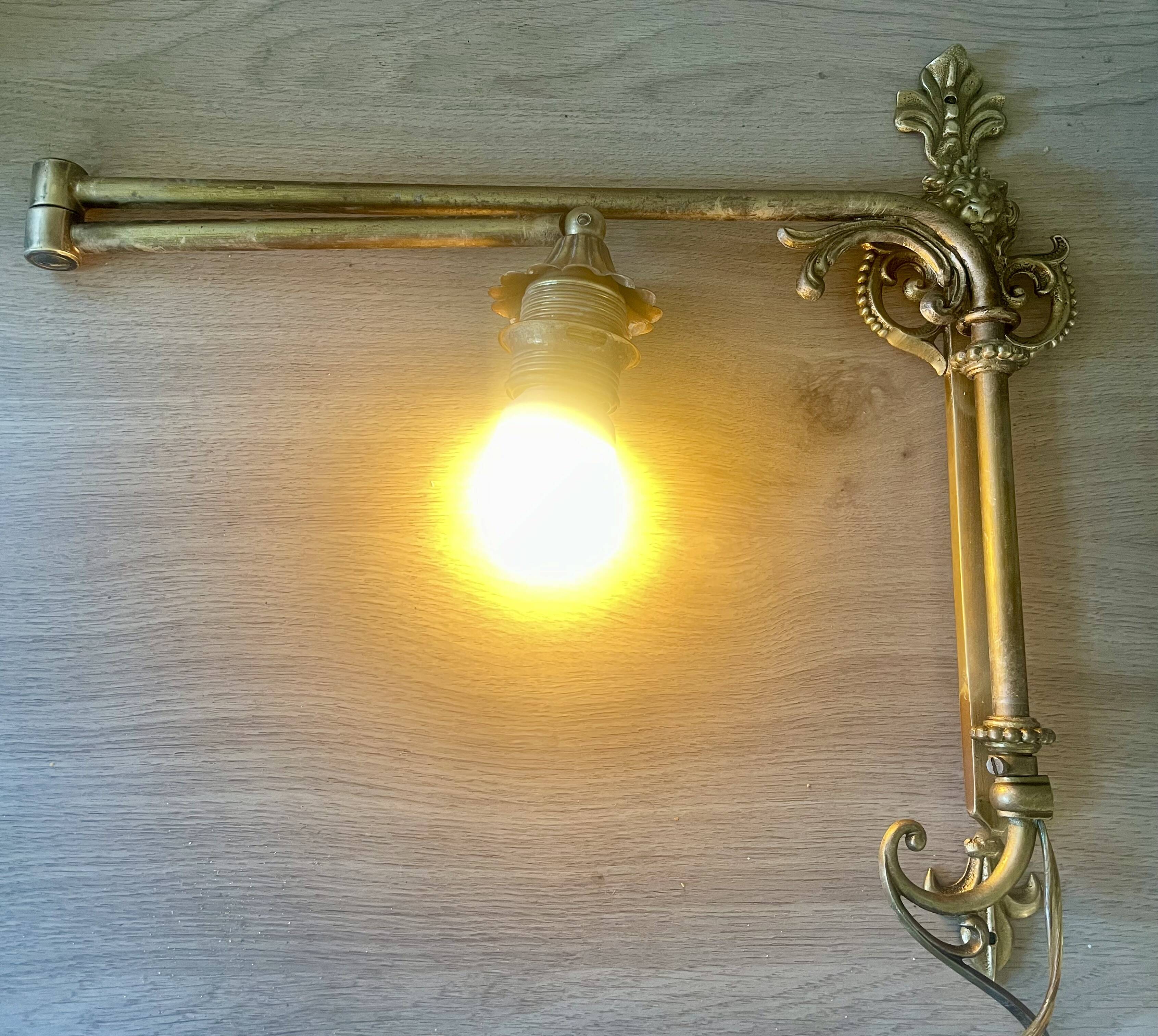 Adjustable wall light in brass and gold metal.