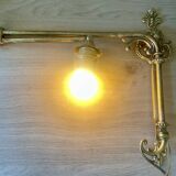 Adjustable wall light in brass and gold metal.