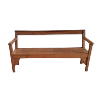 Church bench in fir tree with armrests