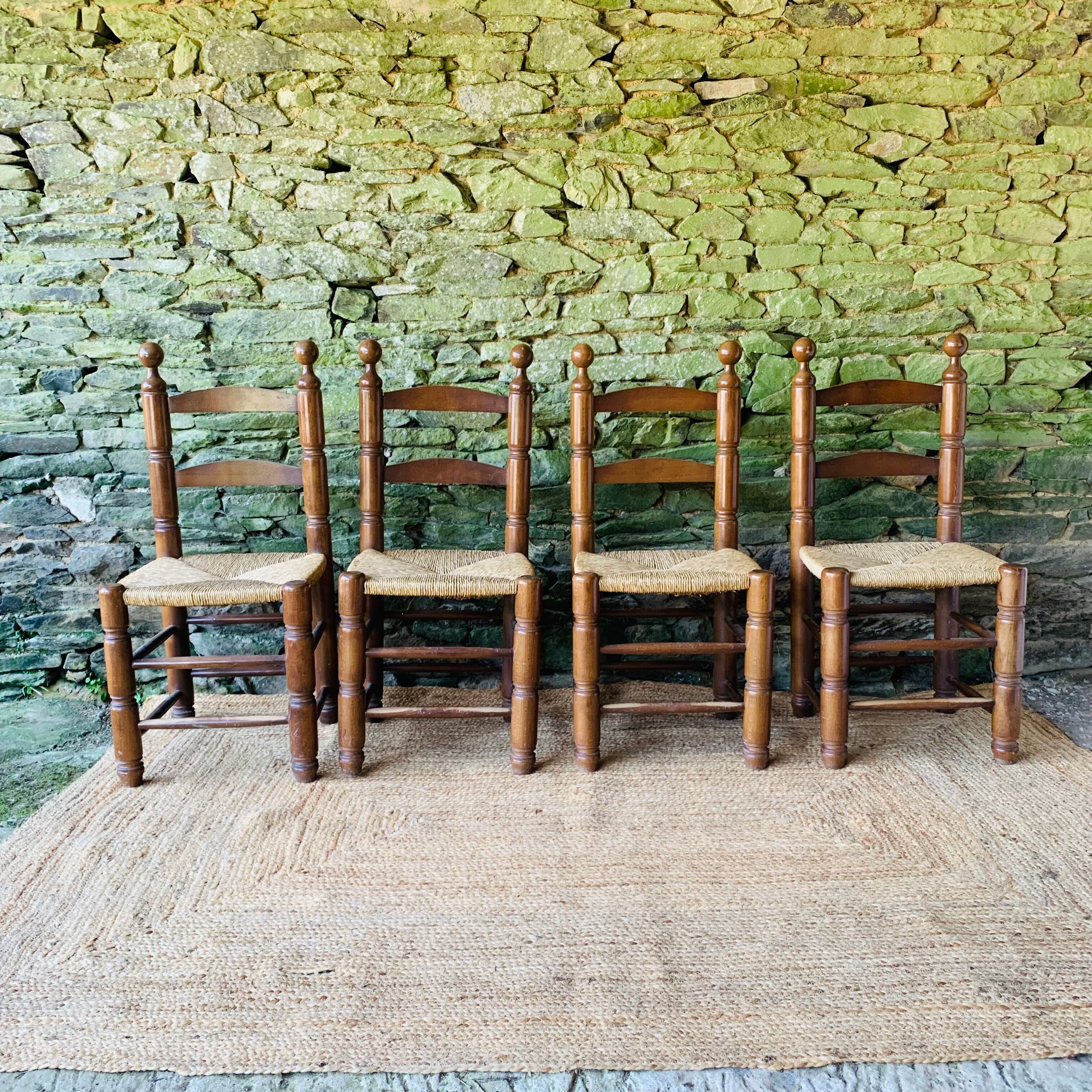 Set of 4 solid wood chairs with straw seats.