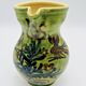 Green stoneware pitcher with flower and brown bird decoration