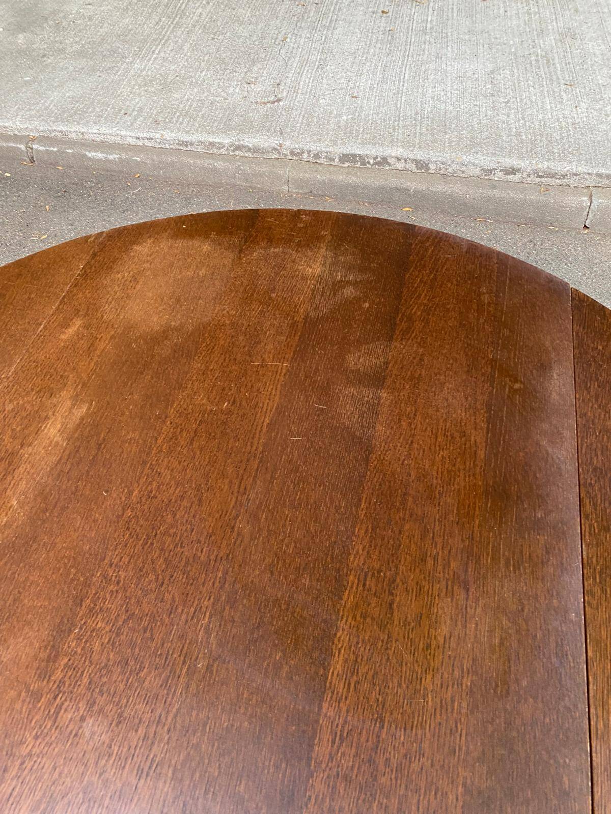 Round kitchen or dining table with extendable leaves in dark wood.
