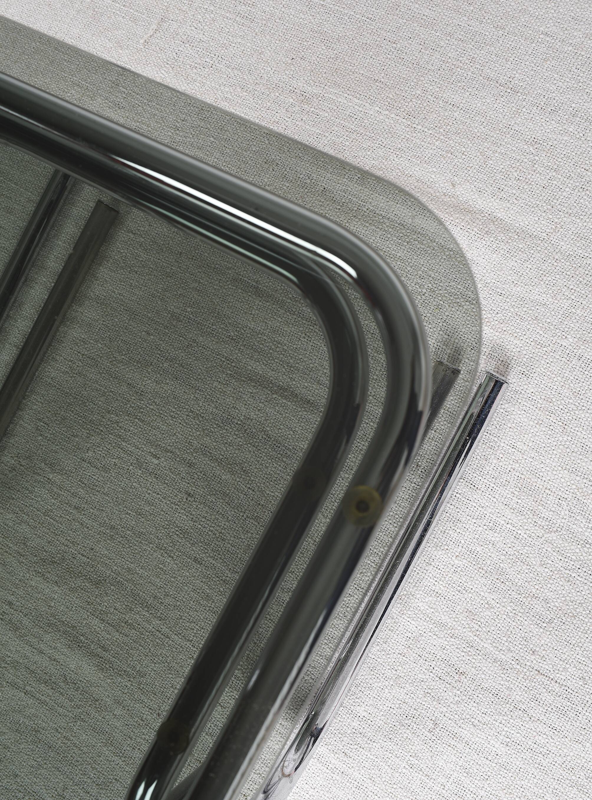 Pair of nesting tables in smoked glass and chrome legs.