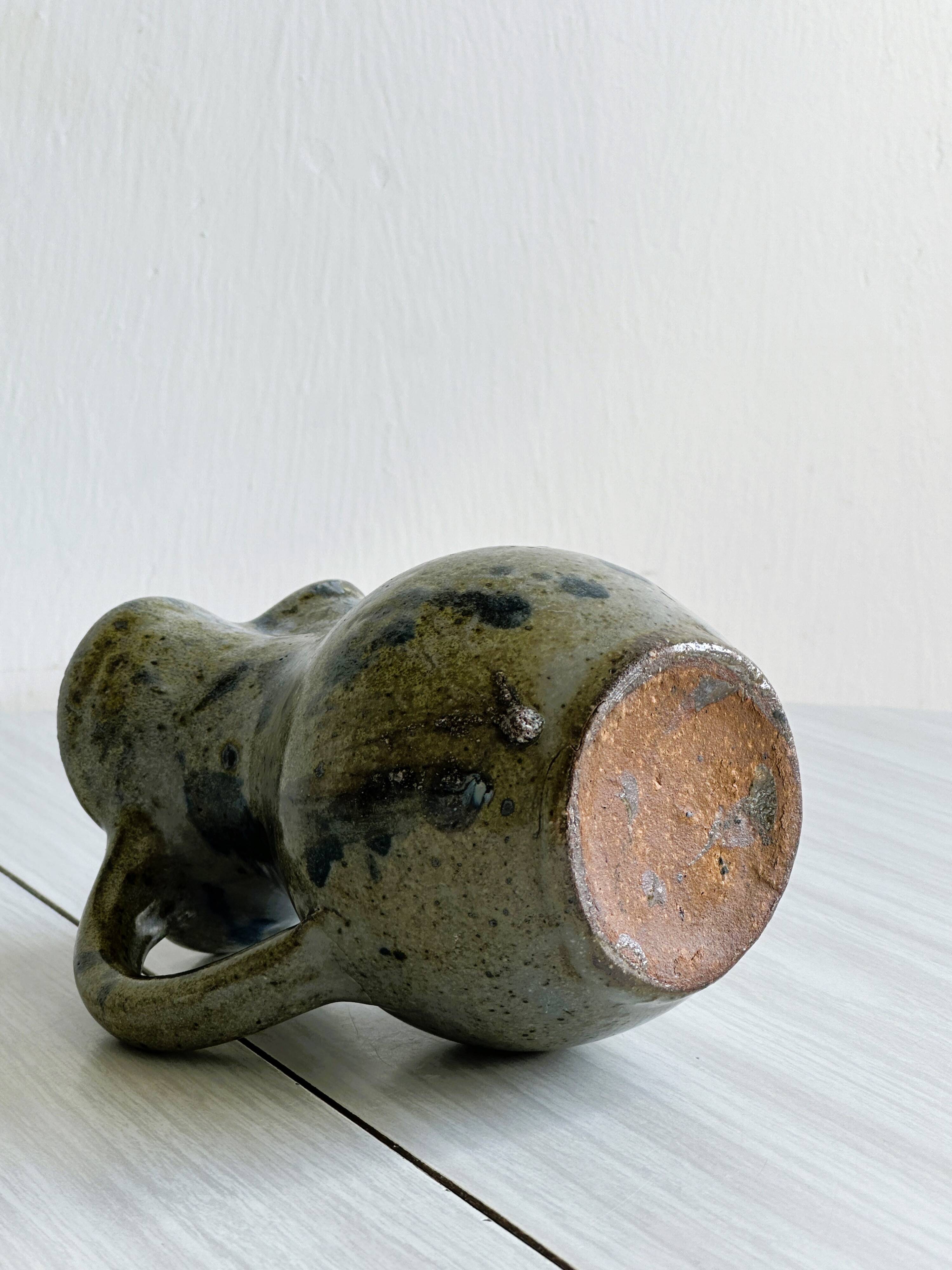 Small handcrafted ceramic pitcher with spotted enamel