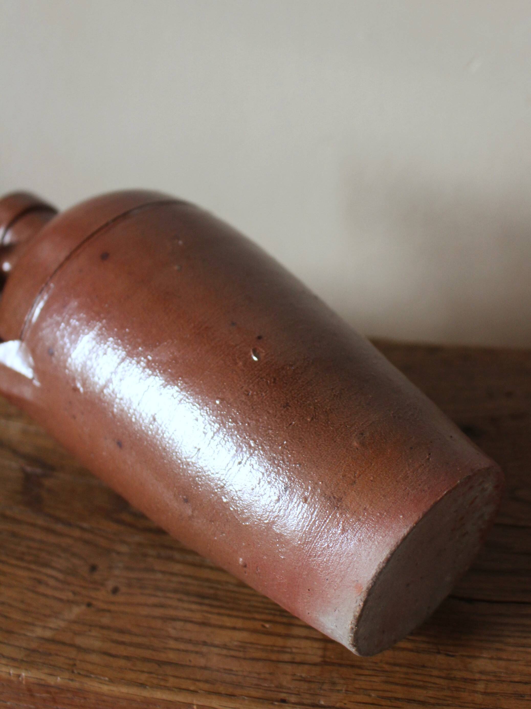Vintage stoneware liqueur bottle with handle and spout.