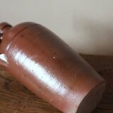 Vintage stoneware liqueur bottle with handle and spout.