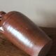 Vintage stoneware liqueur bottle with handle and spout.