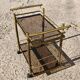 Mid Century Modern bar cart with 2 levels in brass and tinted glass.
