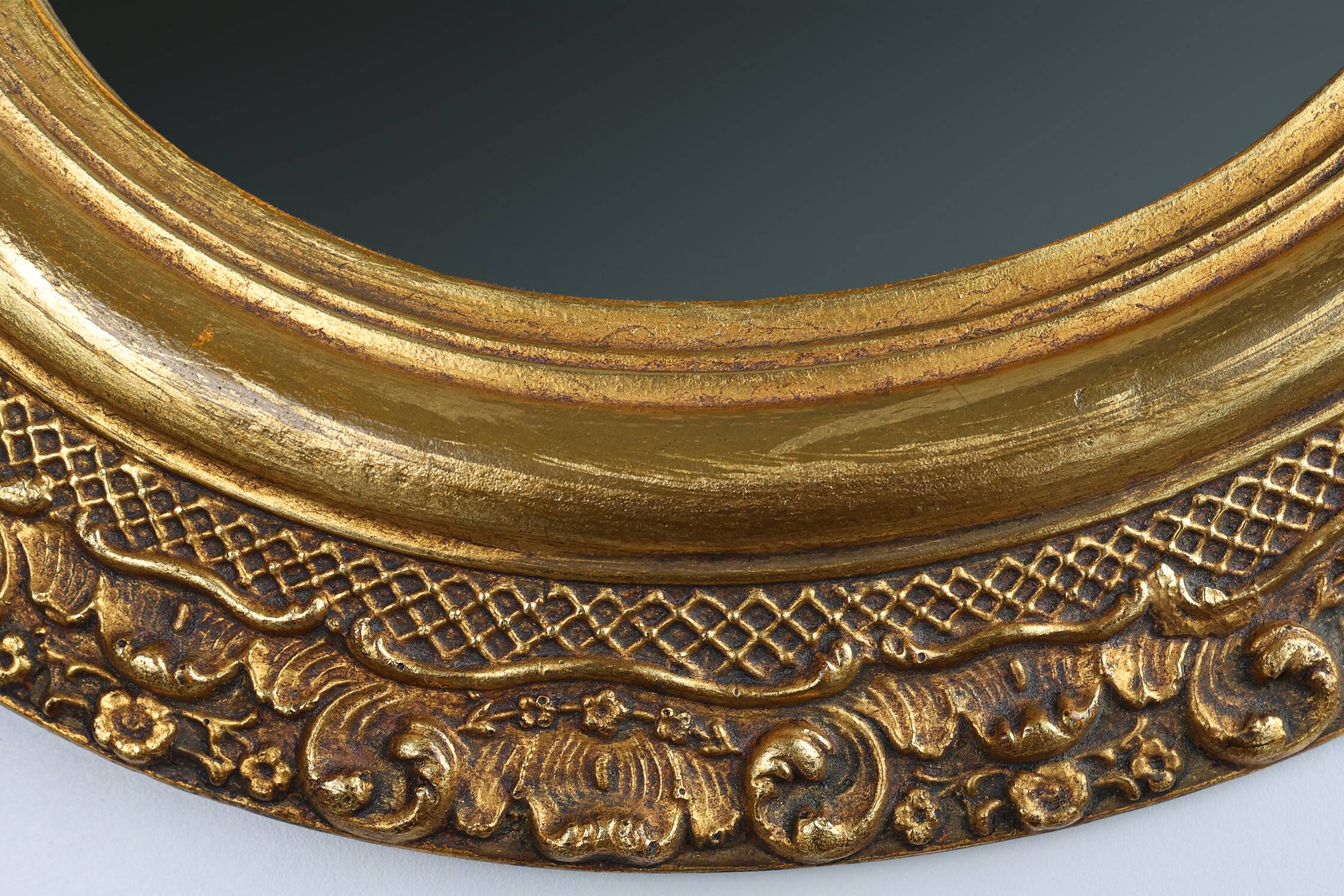 French Baroque style oval mirror in gilded wood with floral decorations