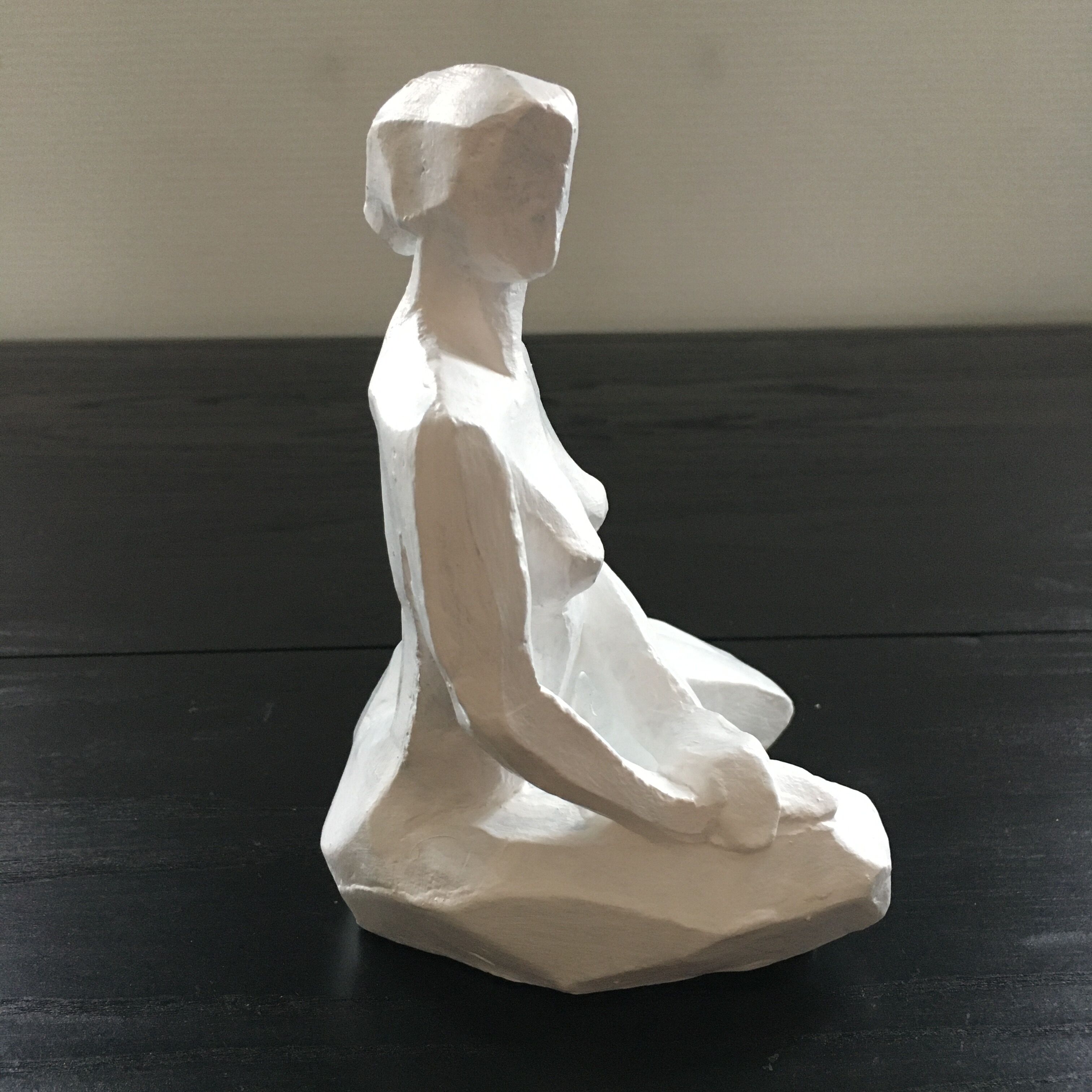 Statuette woman seated in plaster