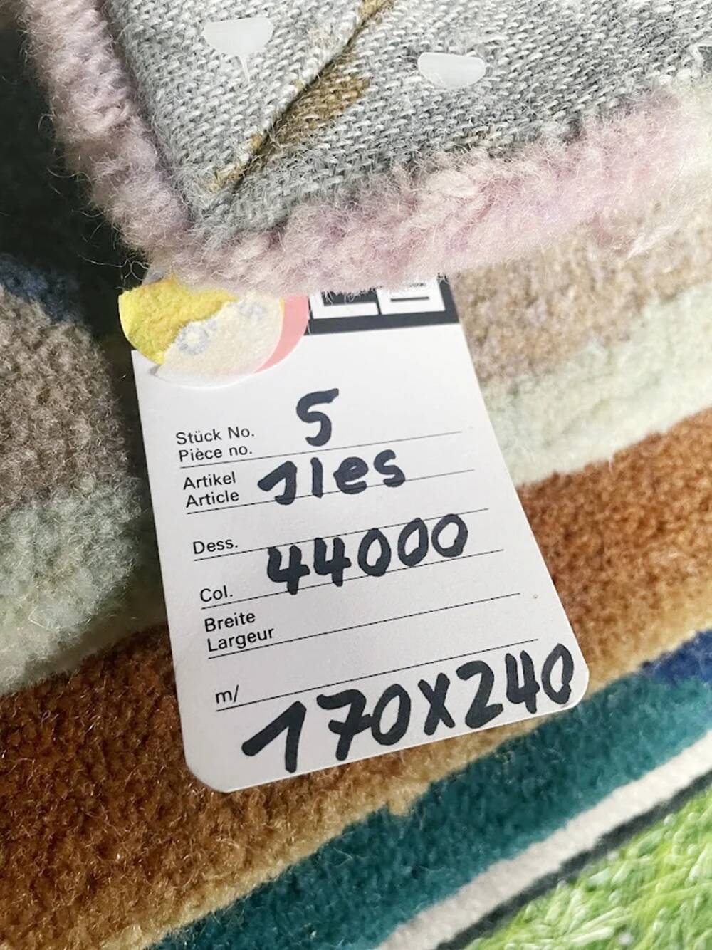 Hand-knotted wool rug by Tisca with a geometric pattern, signed "ILES", France, 1990s.