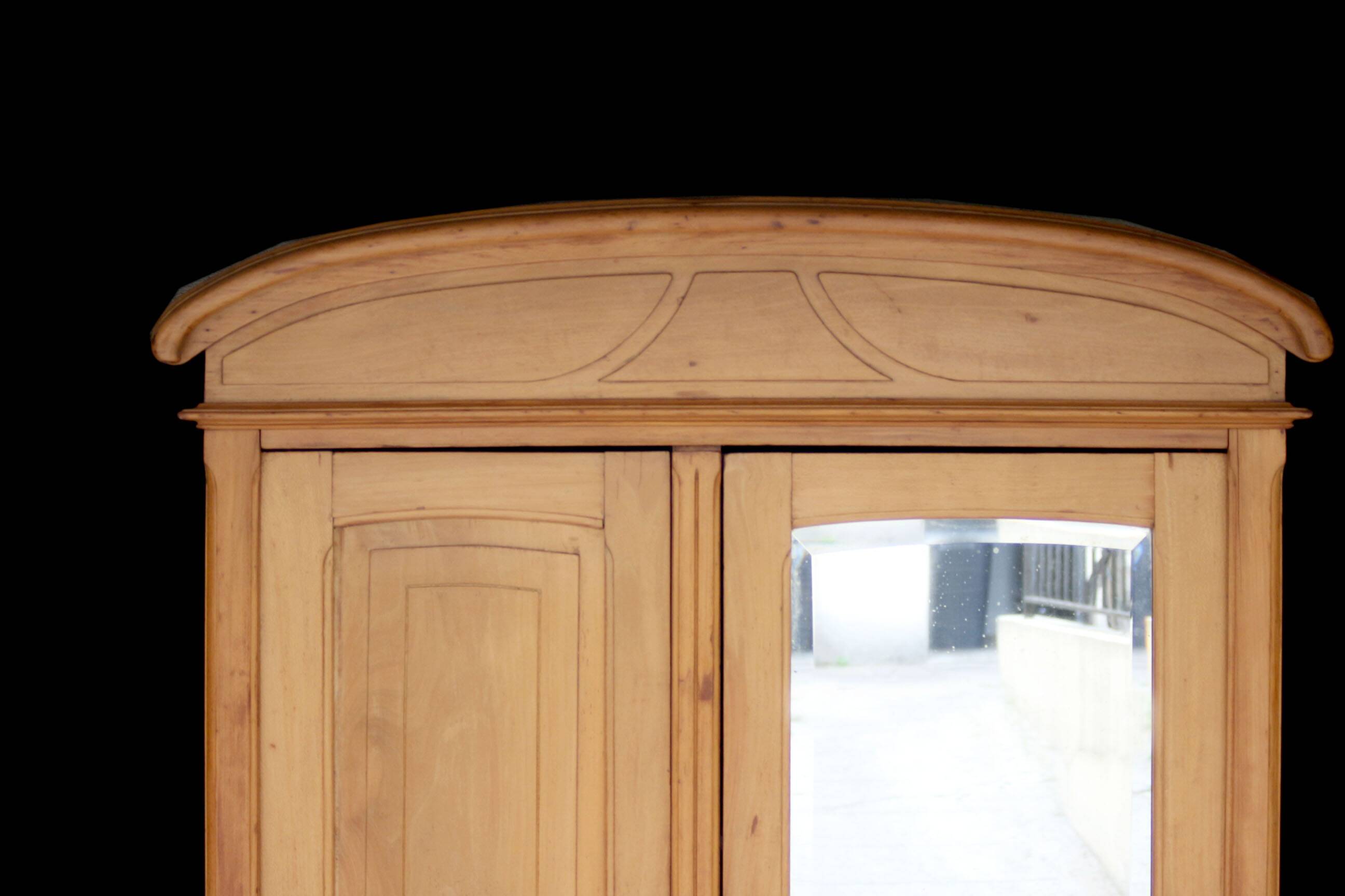 Art Nouveau wardrobe in blond wood with beveled mirror (circa 1909).